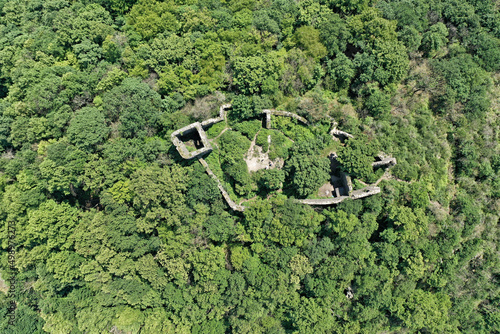 Scrubby walls of castle in the forest photo