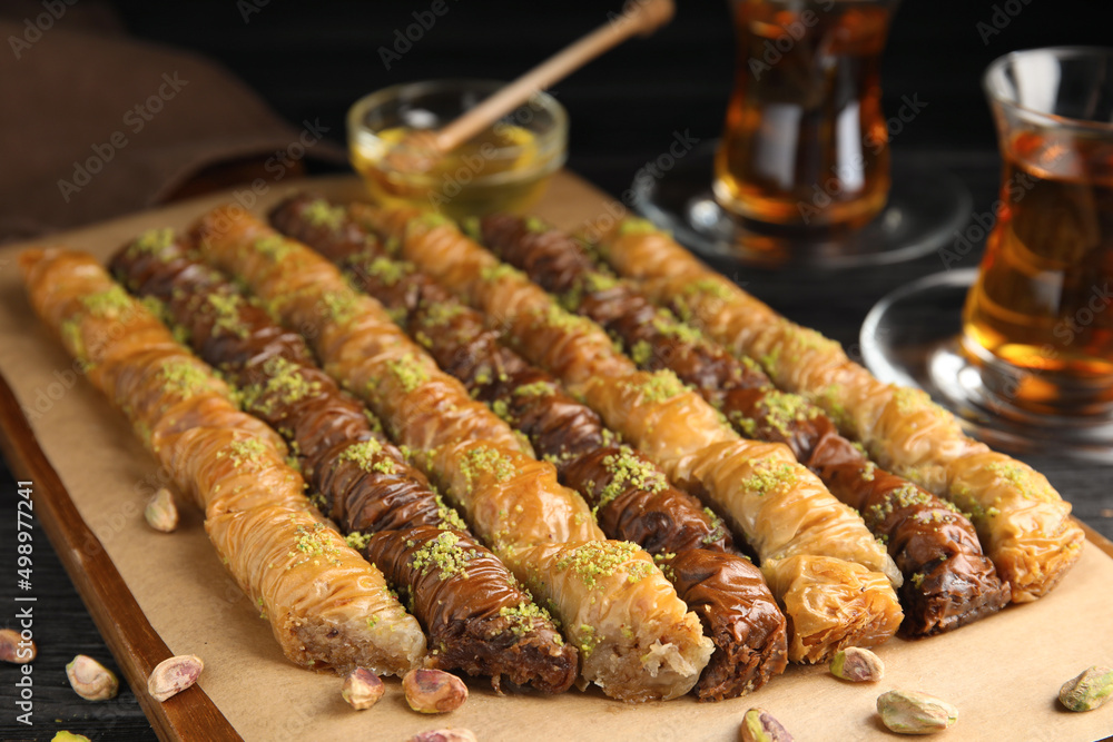 Delicious sweet baklava with pistachios on wooden board, closeup Delicious sweet baklava with pistachios on wooden board, closeup