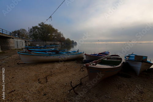 Beautiful sunset sky and fisherman boats reflection in water view of the birds paradise lake manyas photo