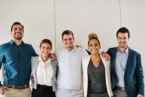 Were team players with the golden mission of reaching success. Portrait of a group of businesspeople standing in an office. photo