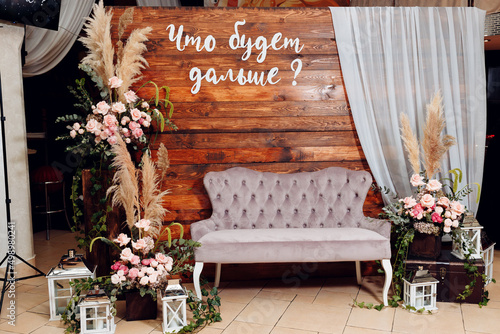 wooden photo zone decorated with natural flowers