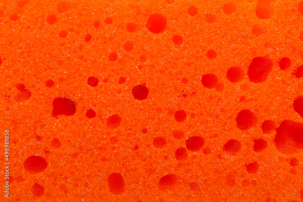 Orange cleaning sponge as background, top view Orange cleaning sponge as background, top view