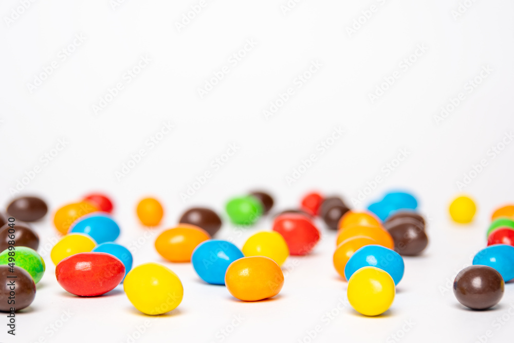 Background of colorful rainbow round candies, copy space, selective focus. Treats for children. Sweets, lollipops based on sugar. Background of colorful rainbow round candies, copy space, selective focus. Treats for children. Sweets, lollipops based on sugar.