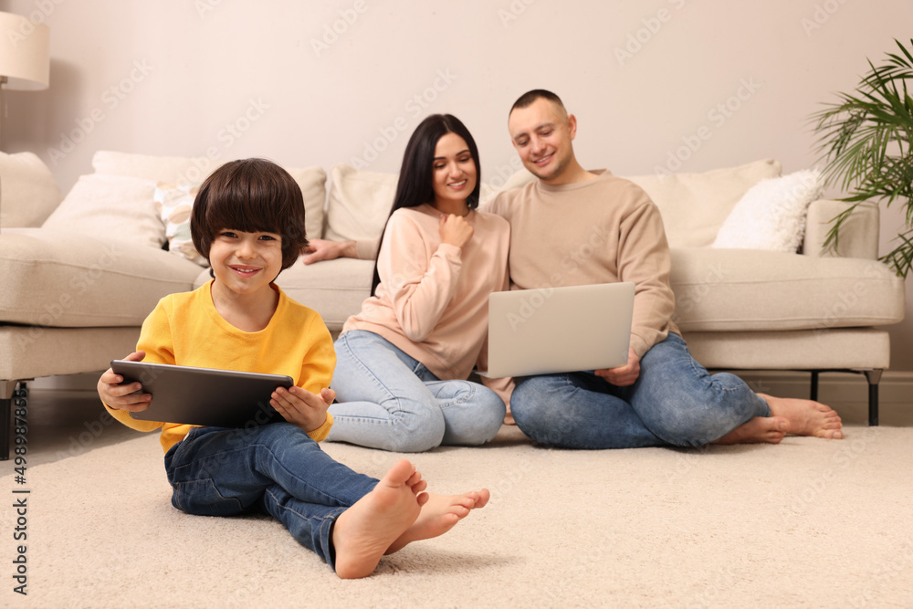 Happy family with gadgets on floor at home Happy family with gadgets on floor at home