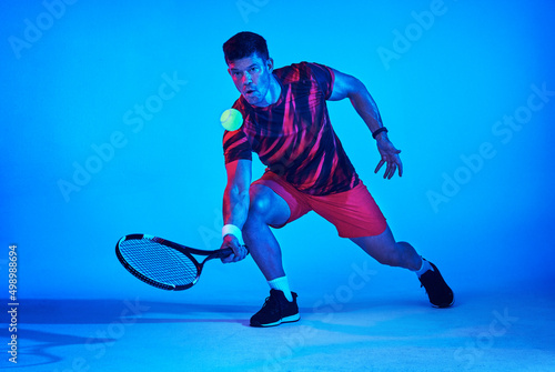 Let the racket do the talking. Blue filtered shot of a tennis player in the studio. photo