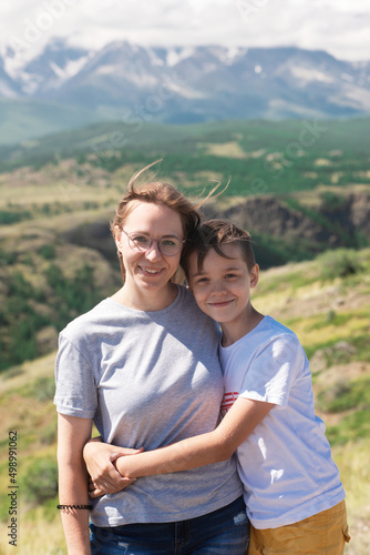 A child embraces mom in the mountain trip. Domestic tourism, travel, lesure and freedom. Altai mountain, beauty summer evening landcape © olinchuk