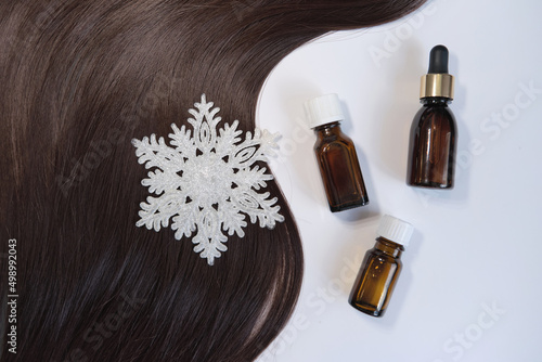 Close-up oil bottle and recovery hair. Concept hairdresser spa salon. hair restoration and treatment after winter. Curl female hair, balm or hair mask isolated on white background.