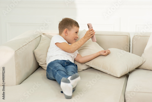 The boy holds the phone and shows his mother something on the phone.