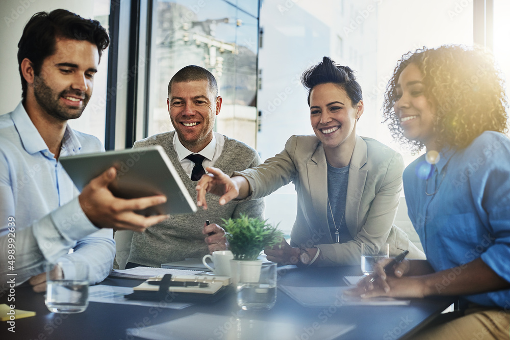 Tell us about this. Shot of a group of colleagues using a tablet while meeting in the boardroom. Tell us about this. Shot of a group of colleagues using a tablet while meeting in the boardroom.