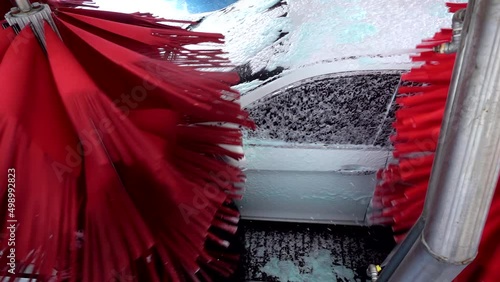 White car moving though automatic car wash machine. The brush moving to clean the car. Slow motion shot