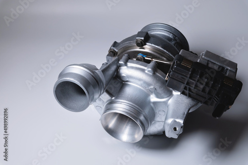 Photos New car parts turbocharged, on a light background.