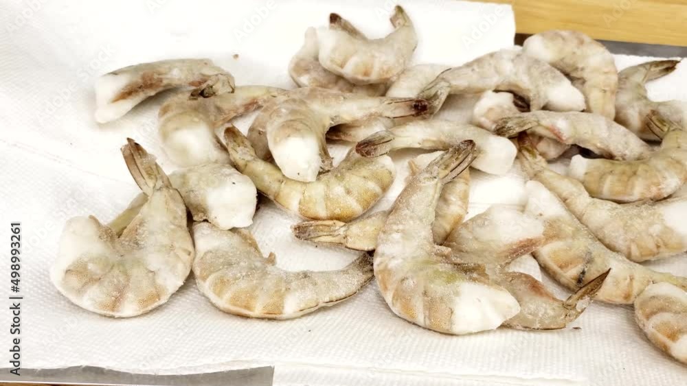 Home cooking - Panning left to right of thawing frozen headless and with shell shrimps preparing seafood for cooking. Home cooking - Panning left to right of thawing frozen headless and with shell shrimps preparing seafood for cooking.