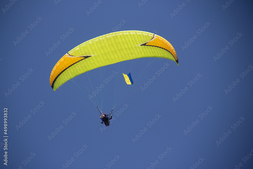 Paragliding with sunset , parachute with amazing sky with Ukrainian flag, Ukraine support Paragliding with sunset , parachute with amazing sky with Ukrainian flag, Ukraine support