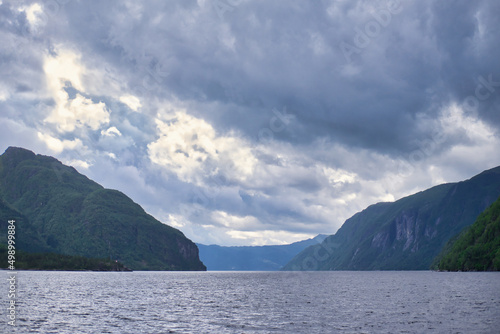 sun and clouds fight above Norwegian fjord