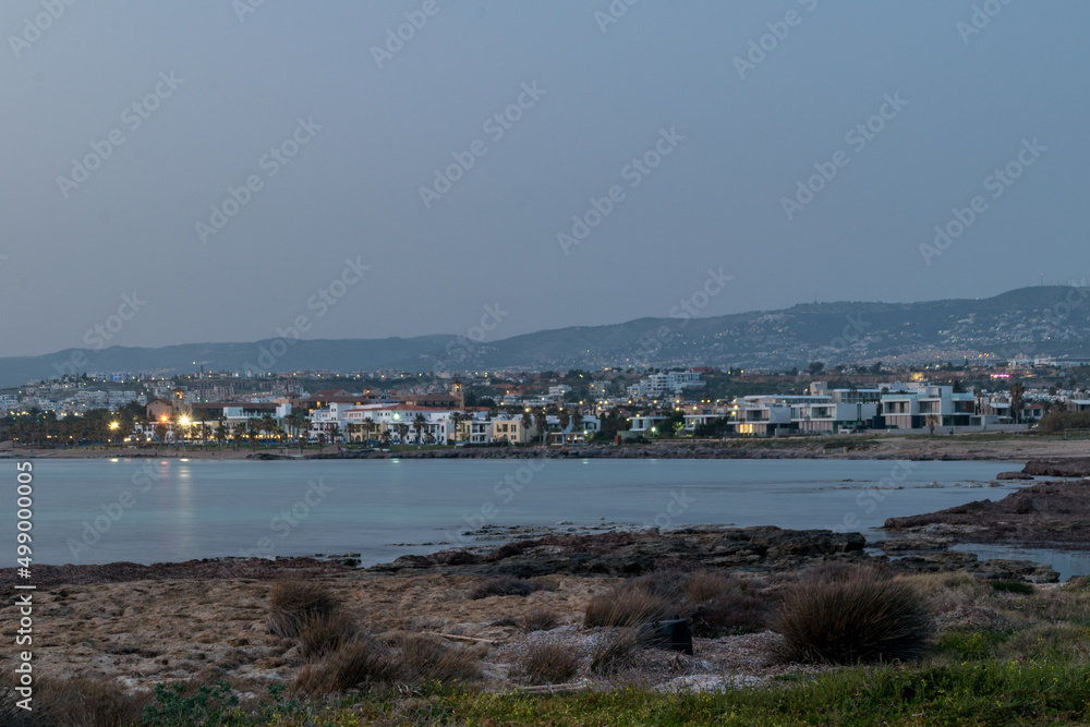 Landmark view on Mediterranean seashore with Paphos city in the evening.