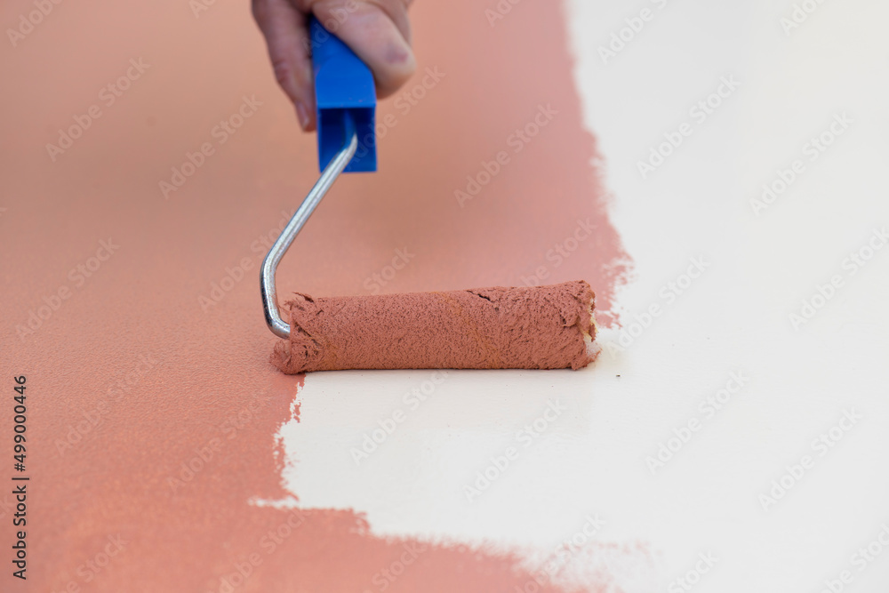Obraz premium Manos con rodillo aplicando pintura a la madera