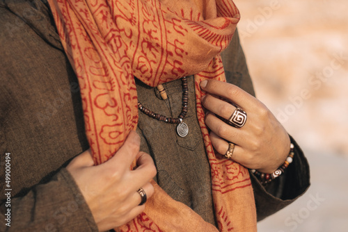 Close-up photograph of a person wearing eco-friendly boho jewelries with hippie sustainable clothing.