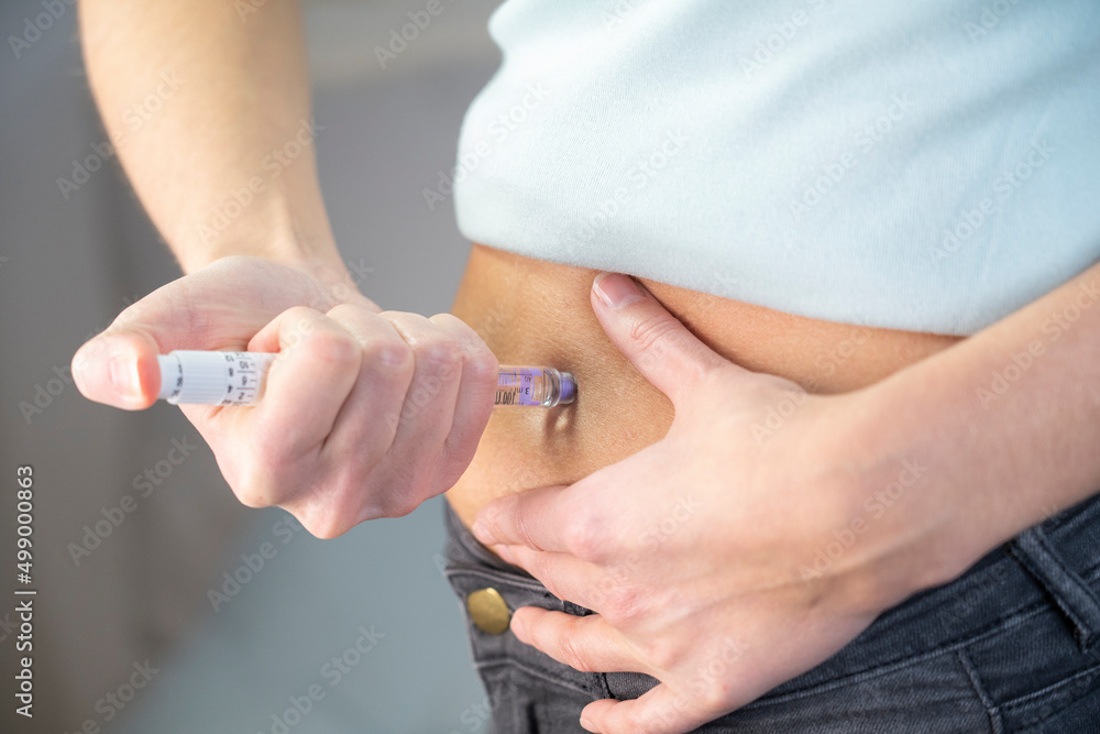 Close-up of the hands and stomach of a diabetic woman giving herself. Close-up of the hands and stomach of a diabetic woman giving herself.