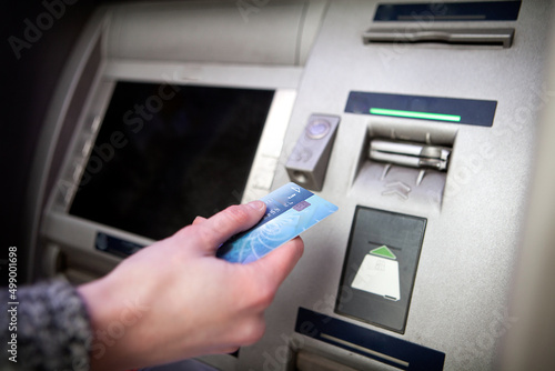 Woman withdrawing money from a bank terminal.