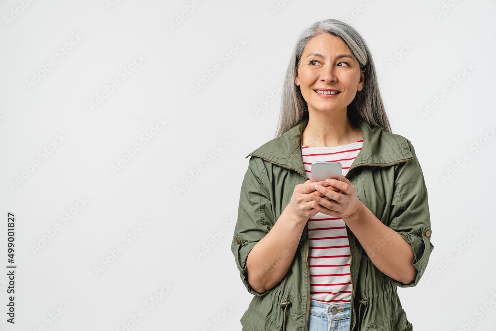 Dreamy pensive contemplation mature middle-aged woman mother grandmother using cellphone for mobile application, e-learning, e-banking online, social media surfing isolated in white background Dreamy pensive contemplation mature middle-aged woman mother grandmother using cellphone for mobile application, e-learning, e-banking online, social media surfing isolated in white background
