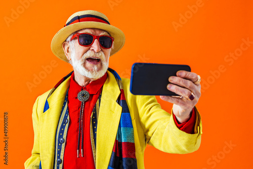 Cool senior man with fashionable outfit portrait - Funny old male person with cool and playful attitude on colorful background photo