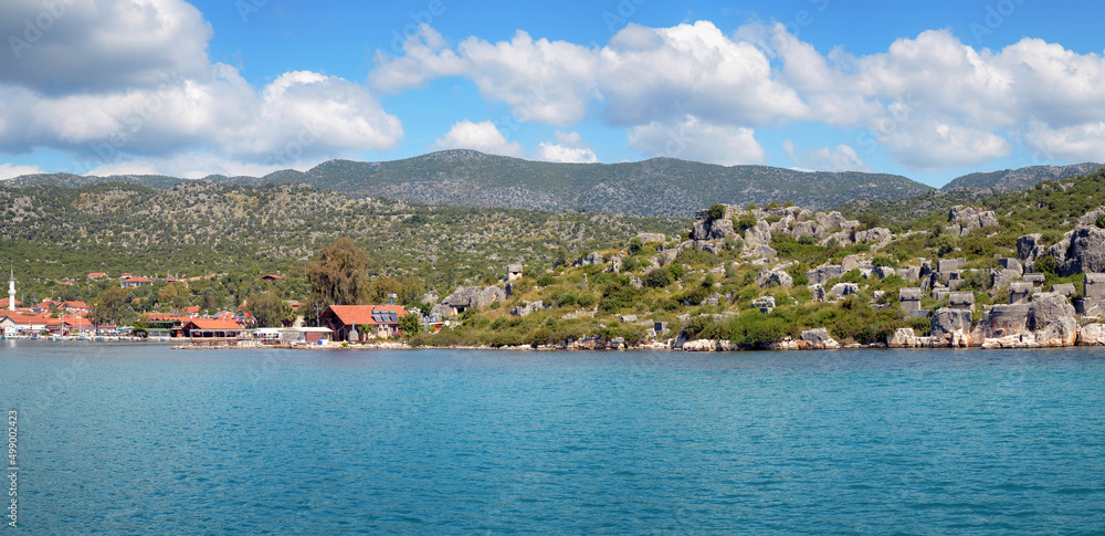 Fototapeta premium Panoramic view of ancient Lycian Simena town and modern Uchagiz village on sunny day. Simena, Turkey.