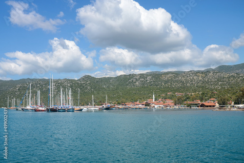 View of Uchagiz village and yachts at its shore on sunny day. Simena, Turkey.