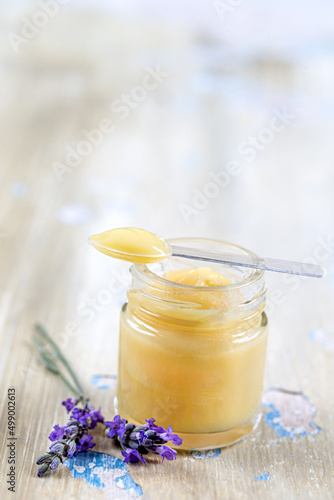 Fotografie Close up of a jar of royal jelly covered with a spoon with sprigs