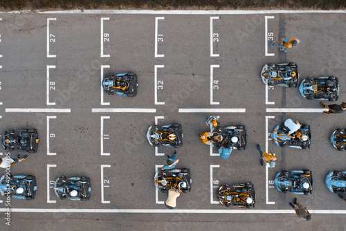 Aerial top view of racing go-kart track with road markings and karts preparing for competition on race starting line