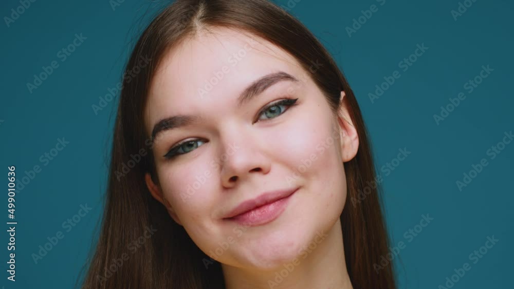 Pretty smiling young girl with healthy smooth skin looking at camera, closeup. Positive emotions. Skincare products ad Pretty smiling young girl with healthy smooth skin looking at camera, closeup. Positive emotions. Skincare products ad