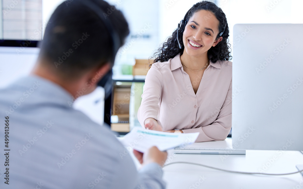 Would you take a look at this paperwork. Shot of a young call centre agent sitting and working with a colleague in the office. Would you take a look at this paperwork. Shot of a young call centre agent sitting and working with a colleague in the office.
