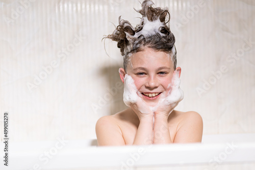 Happy bathing baby with foam on his head