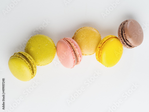 Multicolored French macaroons on a white background. Minimalism. Pastel shades. Supermarket, restaurant, hotel, bakery. Advertising, banner, invitation. There are no people in the photo.