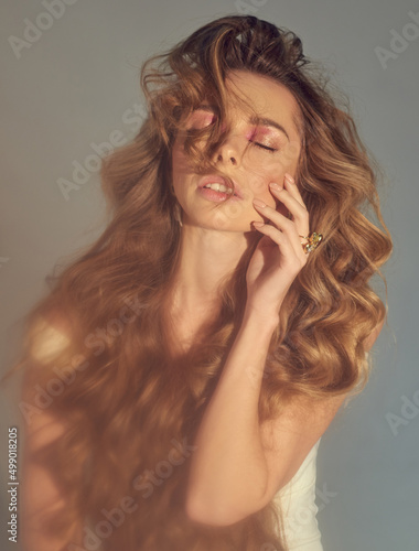 Young attractive women model presenting your jewelry . Wearind white dress. Nude makeup, perfect skin, long hair. White background.