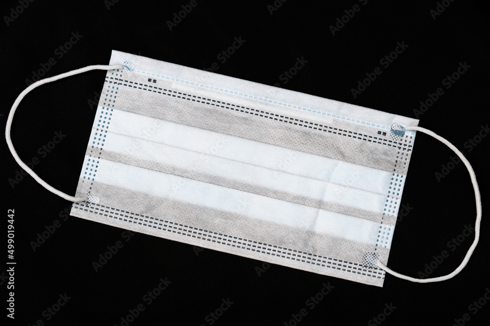 Medical mask on a black background. Gauze dressing as a means of combating and preventing airborne diseases. Medical mask on a black background. Gauze dressing as a means of combating and preventing airborne diseases.