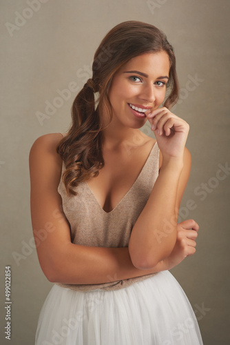 Its hard not to notice something so beautiful. Studio shot of an attractive young woman posing against a brown background.