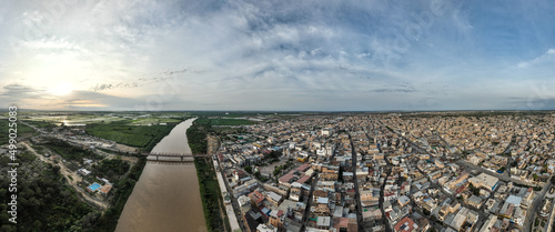 Panoramic shot of the river, the bridge and the city of Tumbes, Peru. At sunset