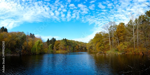 Beautiful autumn landscape with lake and trees. Sunny October day at lake with stunning mirror reflections in water. Sharovka, Ukraine.  photo