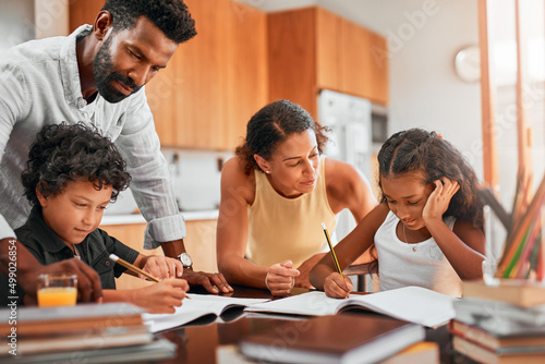 Help your child manage his or her time. Shot of parents helping their two children with their homework.