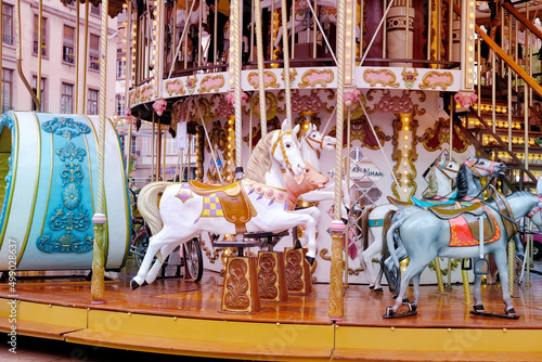 children's carousel is decorated with multicolor lights, decorations, a fairground ride with horses for children, the concept of a holiday, Christmas, family fun