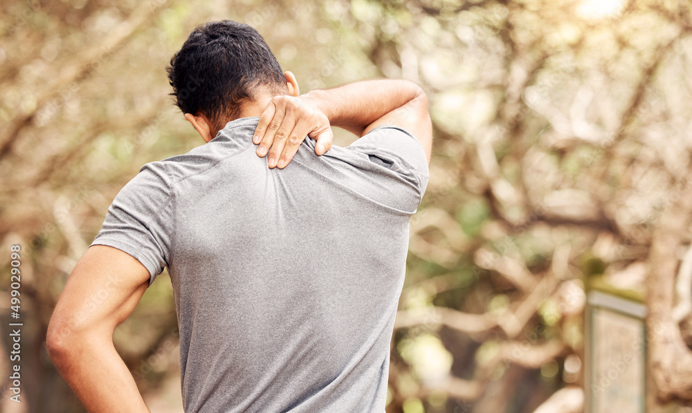 You didnt come this far to only come this far. Rearview shot of an unrecognisable man experiencing neck pain while working out in nature. You didnt come this far to only come this far. Rearview shot of an unrecognisable man experiencing neck pain while working out in nature.