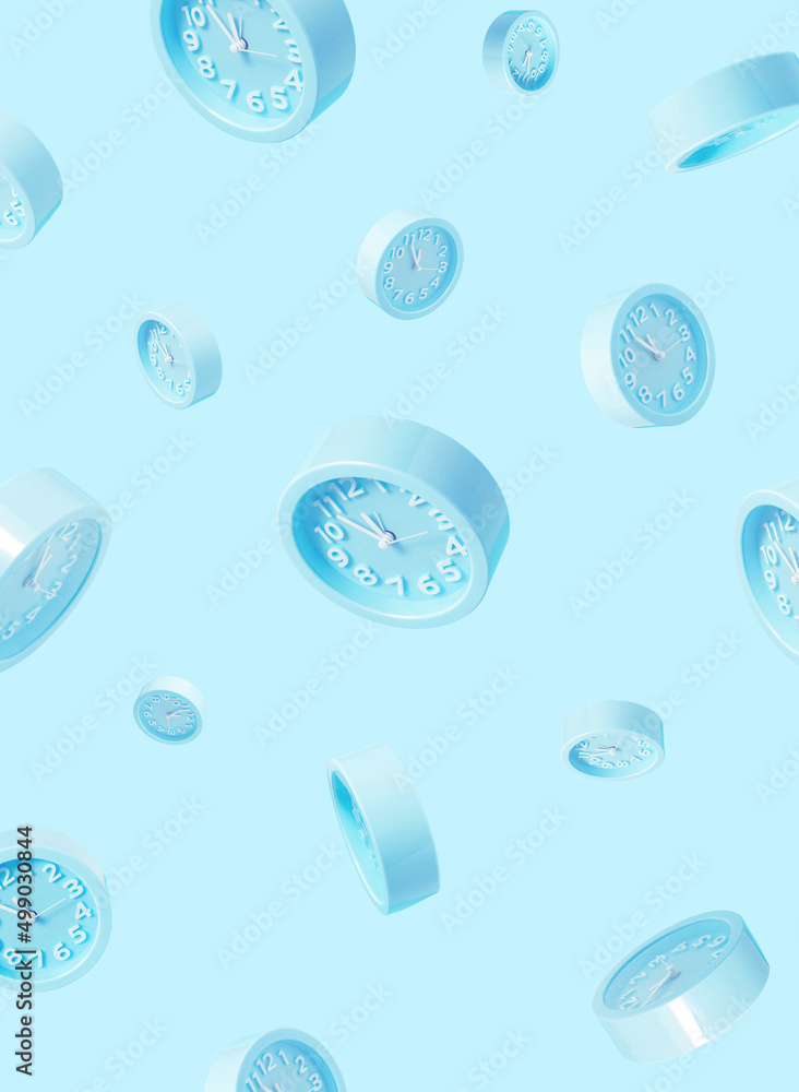 Pastel blue  wall clocks on blue backdrop falling down. Time concept. Minimal composition alarm clock.Chrismas eve or new year idea.