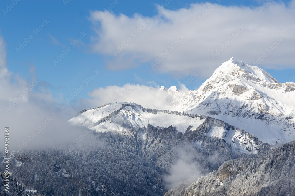 illustration d'un paysage de montagne représenté par une montagne enneigée  avec des nuages