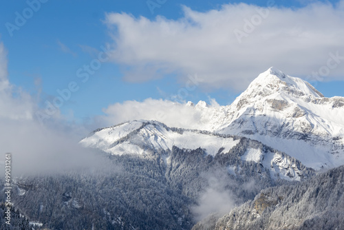 illustration d'un paysage de montagne représenté par une montagne enneigée  avec des nuages © emmanuel
