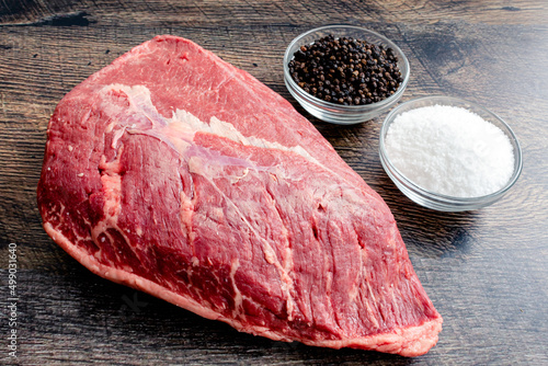 Ingredients for Grilled Picanha Steaks: Whole beef picanha with kosher salt and black pepper on a wood background