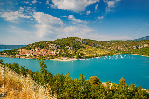 The city on the bank of the artificial lake in France, Provence, lake Saint Cross, gorge Verdone, azure water of the lake and slopes of mountains on a background, small boats, vacations place