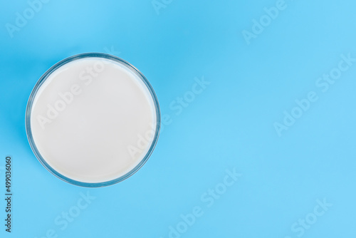 World Milk Day, A glass of white milk isolated on a blue background, close up. Happy Milk Day. Dairy product concept, top view, copy space on right for design or content, nobody, World Milk Day 1 June
