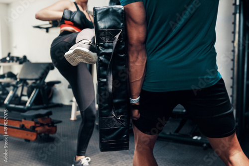 Shes kicking this workout. Cropped shot of an unrecognizable female kick-boxer working out with her sparring partner in a gym.