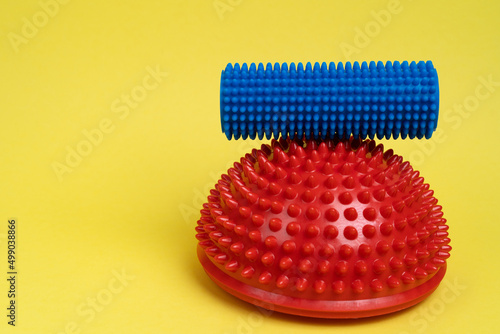 on a yellow background  a red balancer and a blue roller  treatment and prevention of flat feet  hallux valgus