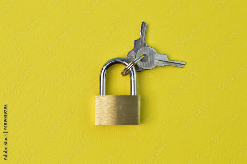Padlock and keys isolated on a yellow background Padlock and keys isolated on a yellow background